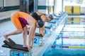 Two female swimmers taking the start position and jumping in a pool Royalty Free Stock Photo