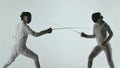 Two professional fencers show masterful swordsmanship in their foil fight. They dodge, leap and thrust and lunge. Shot