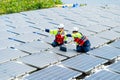 Two professional technician workers point together to the left and discuss about work with solar cell panel system in concept of Royalty Free Stock Photo