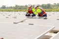 Two professional technician workers sit and work together and work with solar cell panel on base over water reservoir Royalty Free Stock Photo