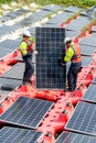 Two professional technician workers stand and hold solar cell panel to check and maintenance the system in concept of green energy Royalty Free Stock Photo
