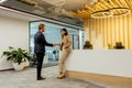 Warm Handshake Between Colleagues In Modern Office Lobby Under Ambient Lighting Royalty Free Stock Photo