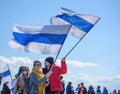 Two protesters on a rally against Russian invasion of Ukraine hold anti-war white-blue-white flags