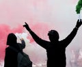 Two protesters after a soccer match with the smoke