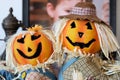 two pumpkin head scarecrow on display next to a babys portrait Royalty Free Stock Photo