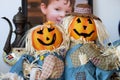 two pumpkin head scarecrow on display next to a babys portrait Royalty Free Stock Photo