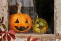 Two pumpkins for Halloween laughing on the windowsill of an old building.