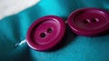 two purple buttons sitting on top of a blue cloth on a table Royalty Free Stock Photo