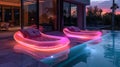 Two purple inflatable chairs by water at night, near a violet building Royalty Free Stock Photo