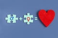 Two puzzle pieces and a heart idea of love on a blue background with signs of a man and a woman. Copyspace for love idea text Royalty Free Stock Photo