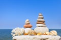 Two pyramids of multicolored stones and shells on the background of the sea Royalty Free Stock Photo