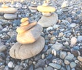 Two pyramids are stacked of gray stones on a pebble beach close up Royalty Free Stock Photo