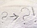 Two question and exclamation marks and arrow written in the snow. The cold frosty texture of the snow and the question Royalty Free Stock Photo