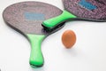 Two rackets and an egg on a white background.