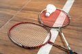 Two rackets and shuttlecock lying on badminton court