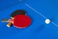 Two rackets for table tennis and a white ball on the blue table. A Ping-Pong game. Sport games Royalty Free Stock Photo