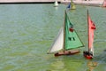 Two radio-controlled yacht models, one with a white and green sail and the flag of Mexico, the other with a white and red sail and Royalty Free Stock Photo