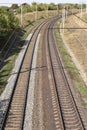Two railroad tracks lie on a crushed rock railroad bank and lead to the right into the woods. Top view Royalty Free Stock Photo