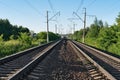 Two railway tracks at summer sunny day. Two railroad lines among the forest. Royalty Free Stock Photo