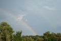 Two rainbows on a blue sky on a summer day