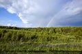 two rainbows in cloudy weather against a gray sky with clouds