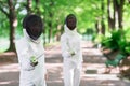 Two rapier fencers women staying in park alley