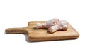 Two raw chicken legs with skin lying on a wooden cutting board. Fresh uncooked meat of poultry isolated on white background Royalty Free Stock Photo