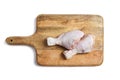 Two raw chicken legs with skin lying on a wooden cutting board. Fresh uncooked meat of poultry isolated on white background. Top Royalty Free Stock Photo