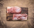 Two raw duck breast on a cutting board on wooden rustic background top view close u Royalty Free Stock Photo