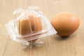 Two raw eggs in plastic box on wood board Royalty Free Stock Photo