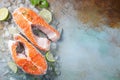 Two raw fresh salmon or trout steaks on ice, rich in omega-3 oil, with lime, thyme and olive oil on a blue rusty Royalty Free Stock Photo