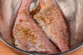 Raw redfish carcasses marinated in spices in metal kitchen bowl Royalty Free Stock Photo