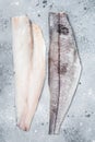 Two raw haddock fish fillets on kitchen table. Gray background. Top view Royalty Free Stock Photo