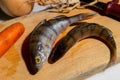 Two raw river bass on a wooden board