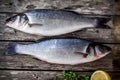 Two raw seabass with fresh thyme and lemon on wooden table Royalty Free Stock Photo