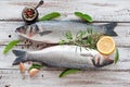 Two raw seabass with spices on an old wooden background Royalty Free Stock Photo