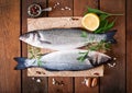 Two raw seabass with spices on an old wooden background Royalty Free Stock Photo