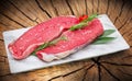 Raw steak meat on white dish with tree trunk background Royalty Free Stock Photo