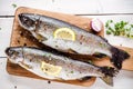 Two raw trouts on cutting board with thyme, lemon and red onion Royalty Free Stock Photo