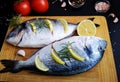 Two fresh dorada fish decorated with lemon
