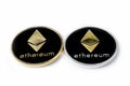 Two real coins of silver and golden cryptocurrency Ethereum, on white background