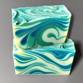 Two rectangular bars of handmade soap featuring green, blue and white swirls