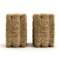 Two rectangular blocks of hay or straw standing upright on a white surface Royalty Free Stock Photo