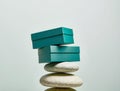 two rectangular teal boxes delicately balanced atop two smooth Royalty Free Stock Photo