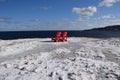 Two red Adirondack chairs on the Winter coast Royalty Free Stock Photo