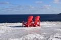 Two red Adirondack chairs on the Winter coast Royalty Free Stock Photo