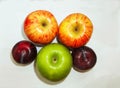 Two red apples and one green apple and two plum on white background Royalty Free Stock Photo