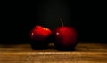 Two red apples on a wooden board on a black background. front view Royalty Free Stock Photo