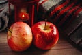 Two Red Apples, Woolen Sweater And A Lantern With A Candle. Cozy Autumn And Winter Concept