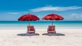 Two red beach chairs and umbrellas on a beautiful white sand beach in front of the ocean on sunny day Royalty Free Stock Photo